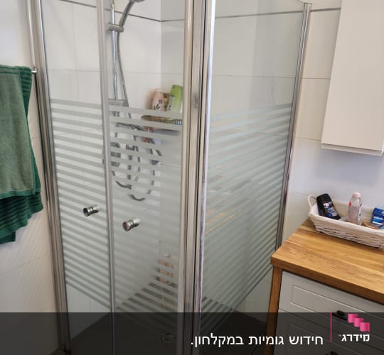 מקלחון זכוכית עם ראש מקלחת ומדף מוצרים